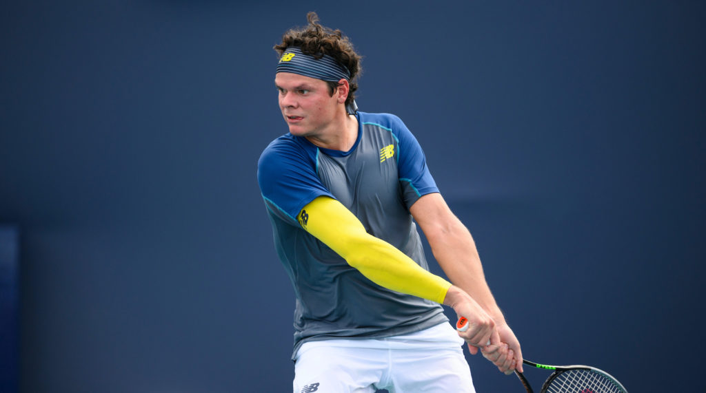 milos raonic hits a backhand at the miami open