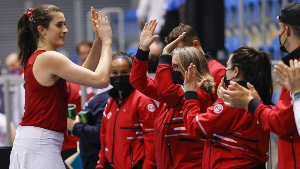 rebecca marino hi-fives her team after winning at the Billie Jean King Cup