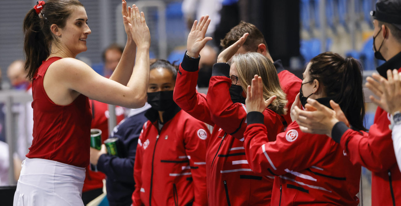 rebecca marino hi-fives her team after winning at the Billie Jean King Cup