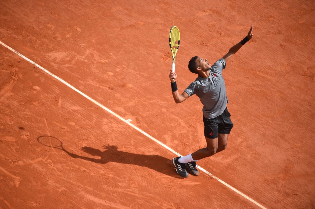 Félix prepares to hit a serve on a clay court