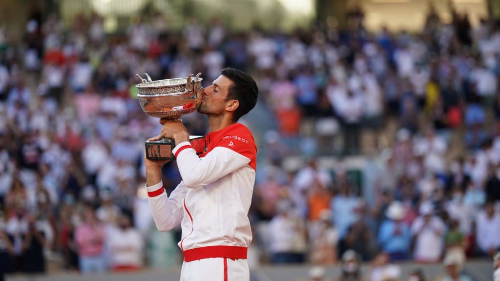 Djokovic kisses the ROland Garros trophy in front of a crowd