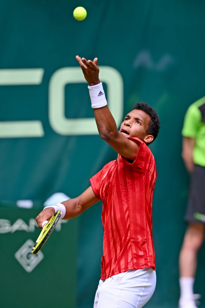 Felix tosses the ball for a serve