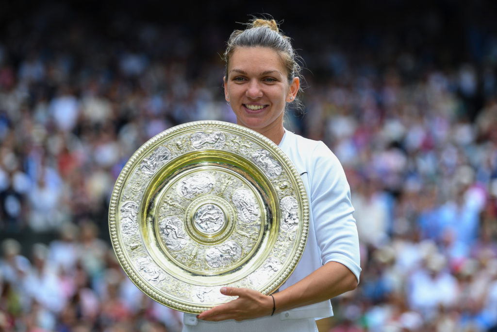 Simona Halep holds the Wimbleon women's trophy and smiles at the camera