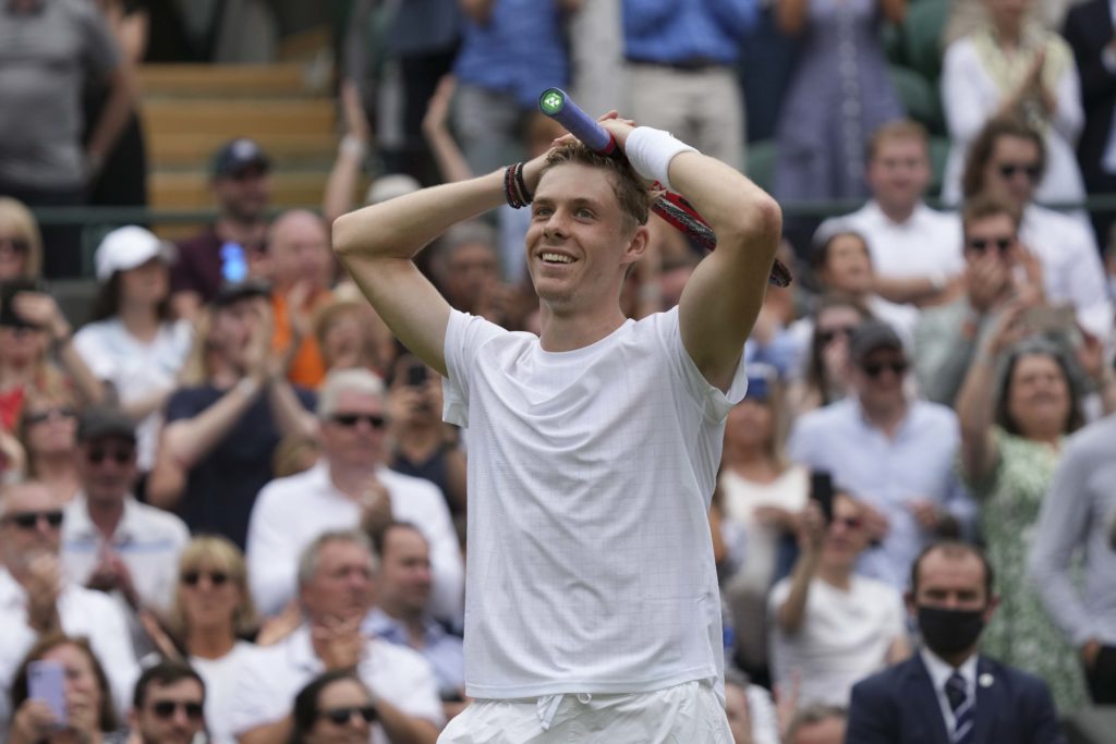 Denis Shapovalov puts his hands on his head and smiles.
