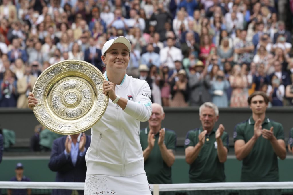 Ashleigh Barty smiles as she holds the Wimledon trophy