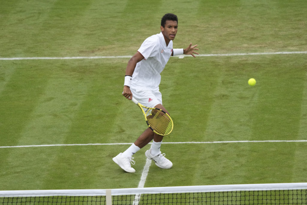 Felix Auger-Aliassime watches a volley he just hit.