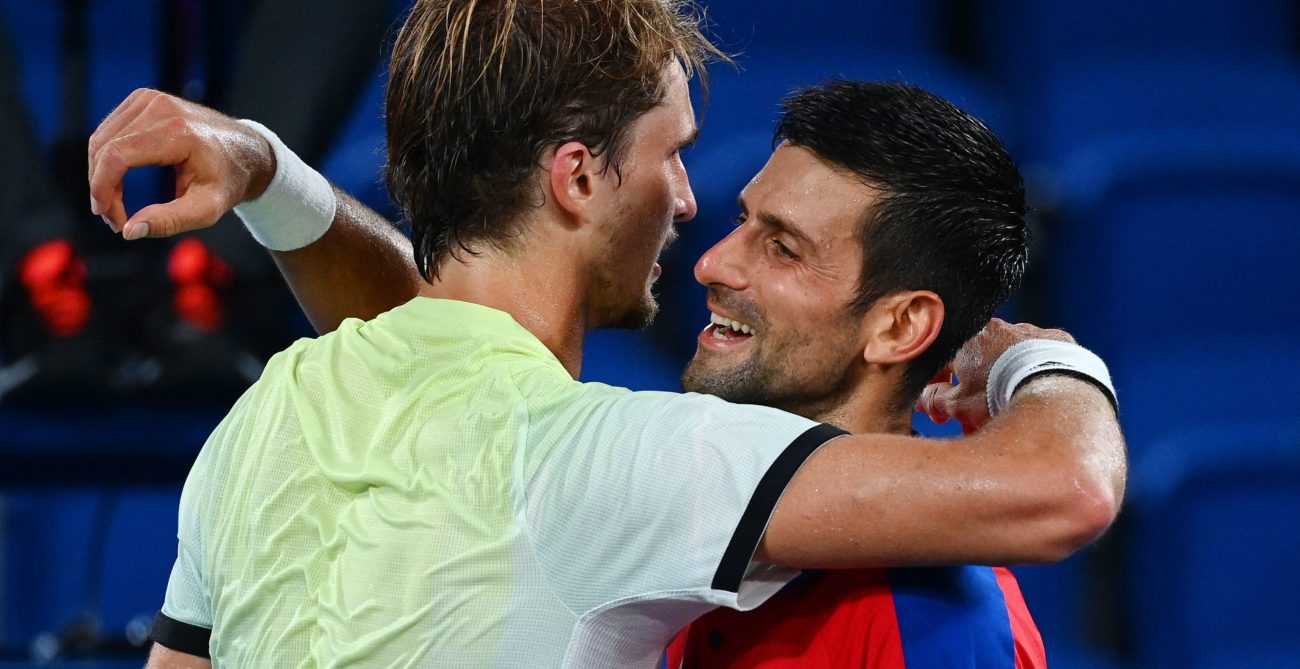 Alexander Zverev and Novak Djokovic embrace at the net