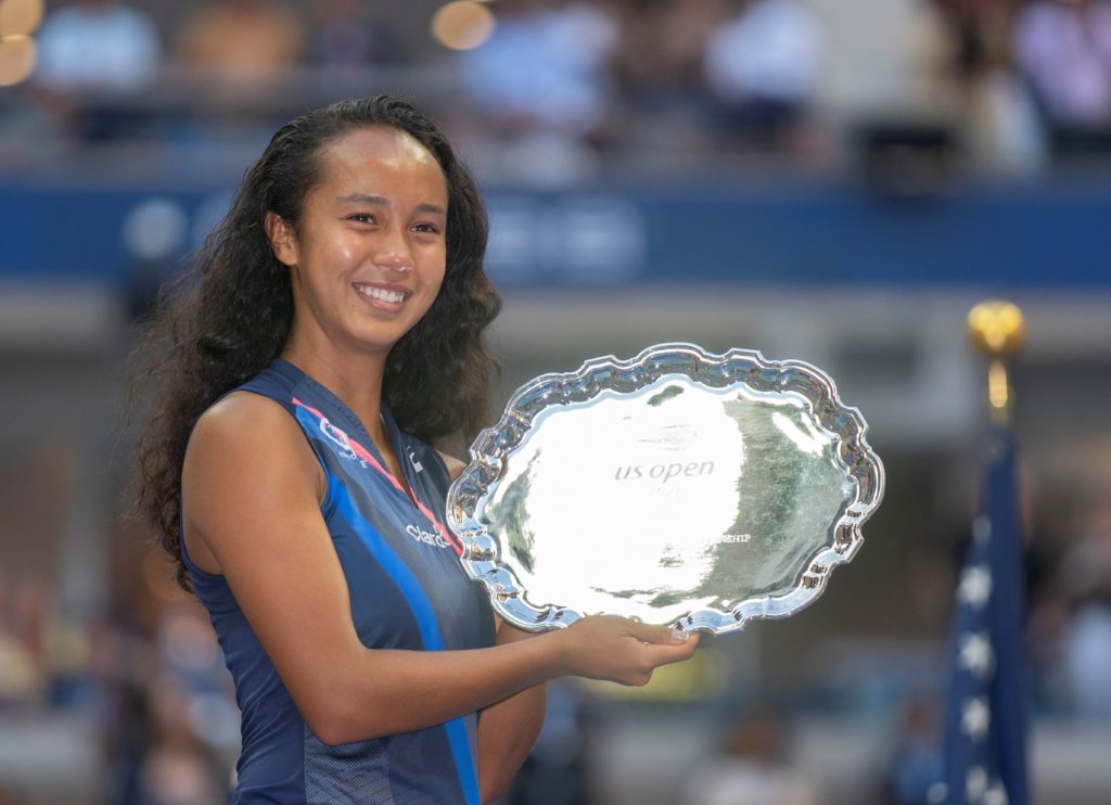 Leylah Fernandez holds her US Open runner-up plate and smiles.
