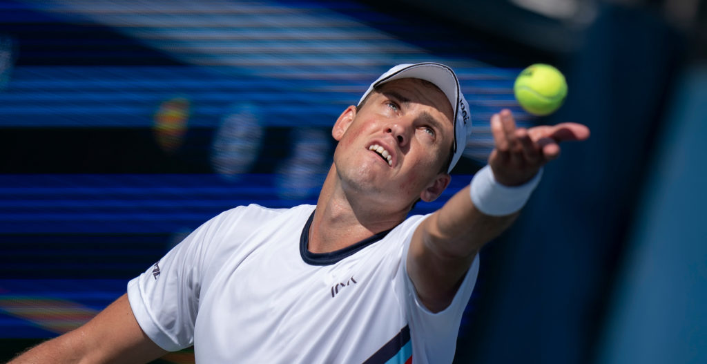 Vasek Pospisil is about to toss the ball to serve.