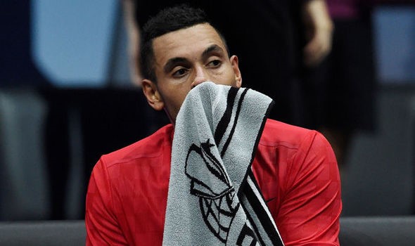 Nick Kyrgios holds a towel to his face