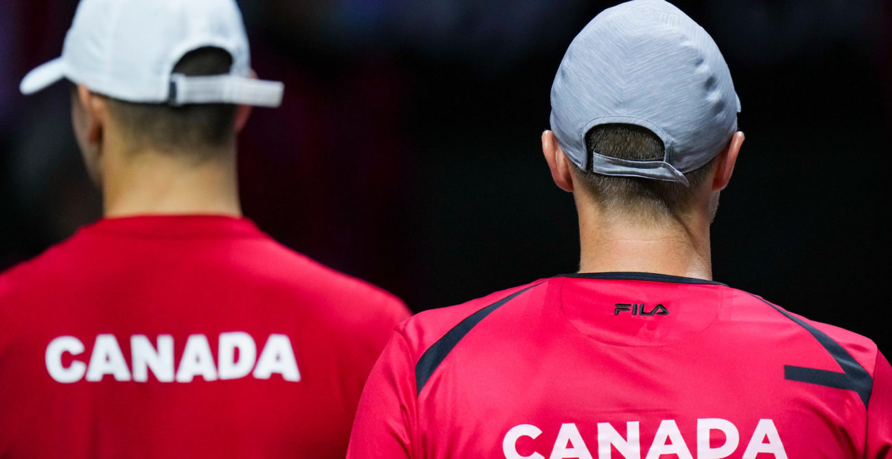 Two players wearing a red shirt with Canada written on, seen from their back
