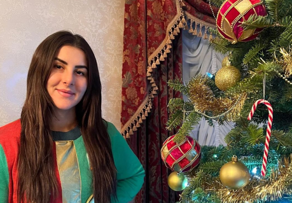 Bianca Andreescu stands next to a Christmas Tree.