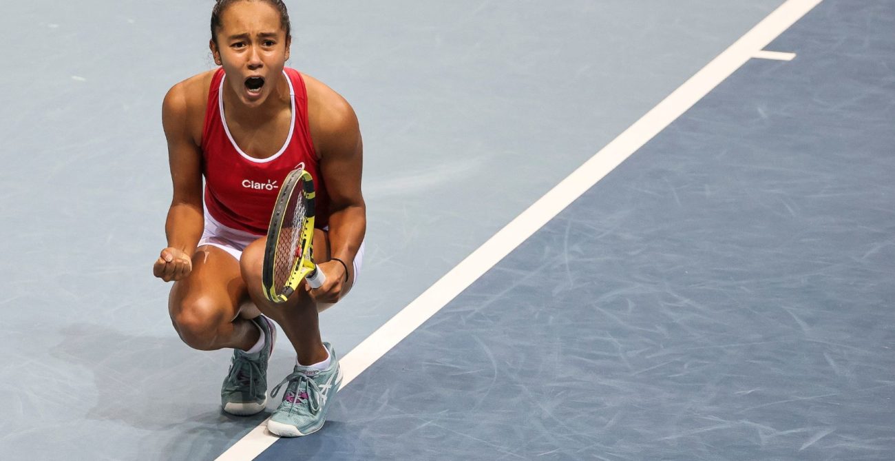Leylah Fernandez crouches on court an yells after a win