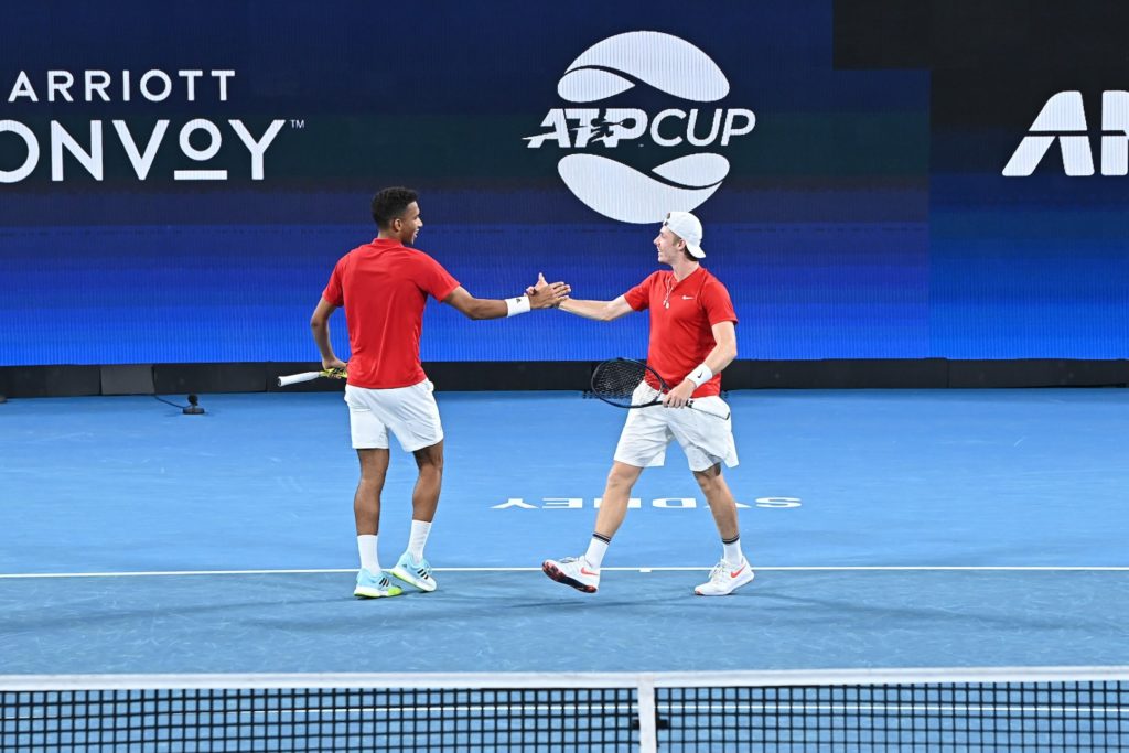 Felix Auger-Aliassime and Denis Shapovalov shake hands and smile playing doubles