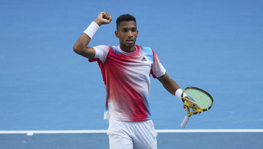 Felix Auger-Aliassime raises his fist in the air.