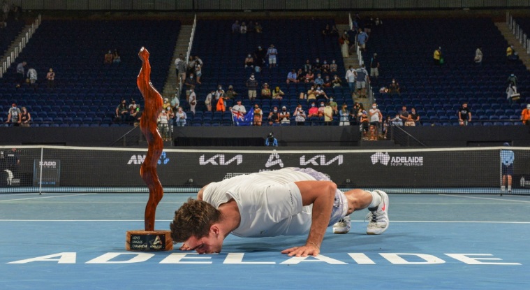 Thanasi Kokkinakis gets down to kiss the Adaliade court