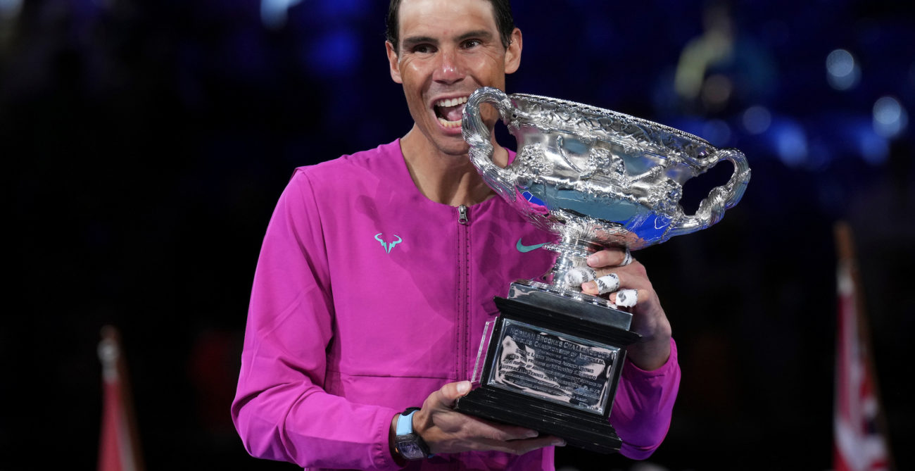 Rafael Nadal bites the trophy.