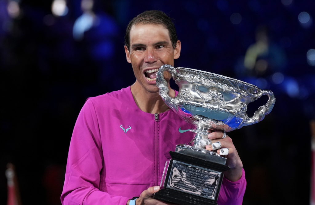 Rafael Nadal bites the trophy.