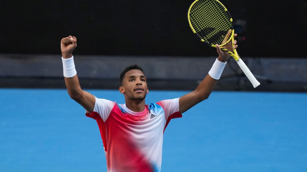 Félix Auger-Aliassime raises his arms in celebration at he australian open