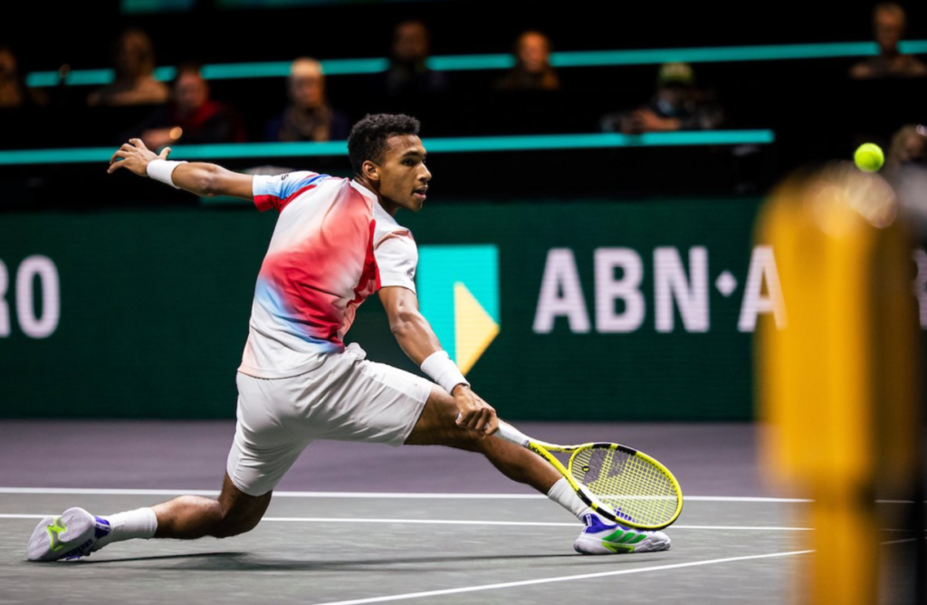 Félix Auger-Aliassime slides into a backhand