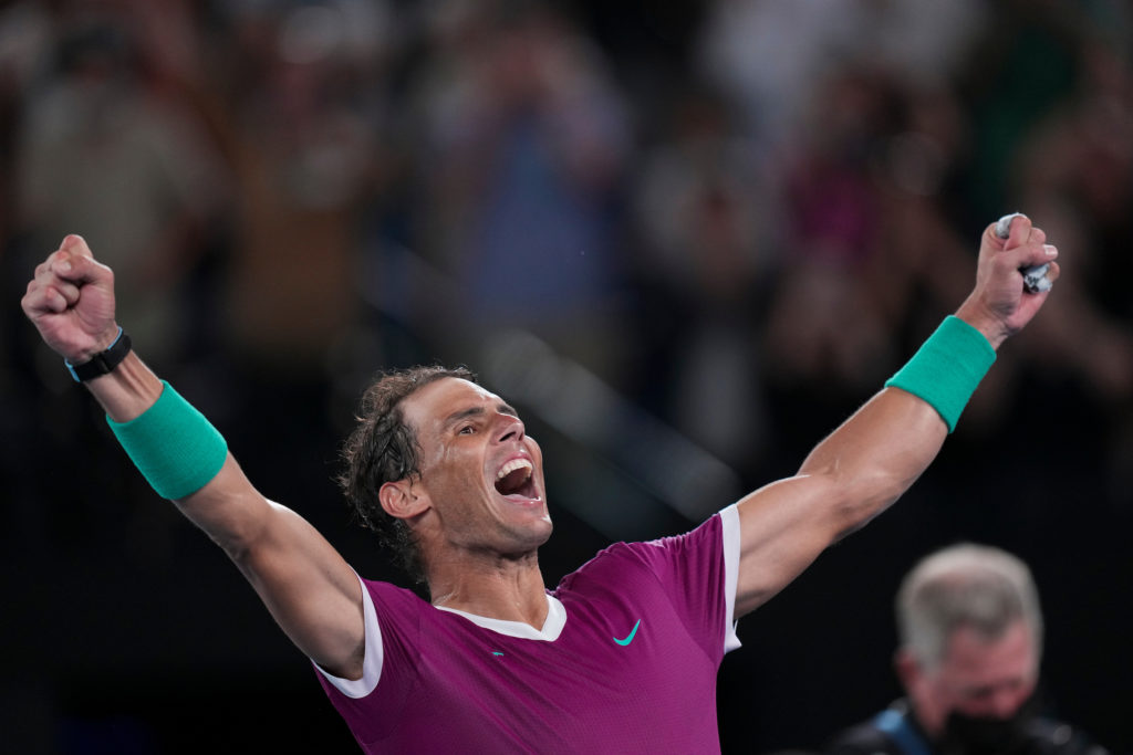 Rafael Nadal raises his arms in the air.