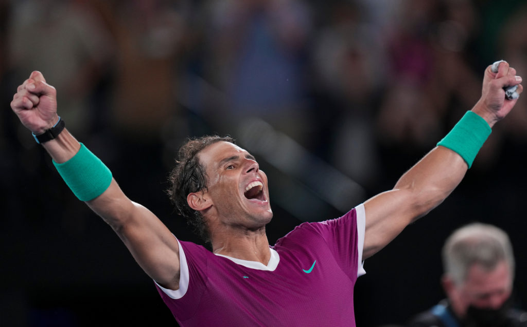 Rafael Nadal raises his arms in the air.