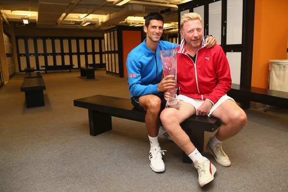 Boris Becker and Novak Djokovic posing with a trophy in the locker room