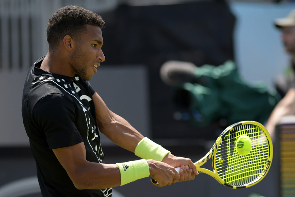 Felix Auger-Aliassime hits a backhand.