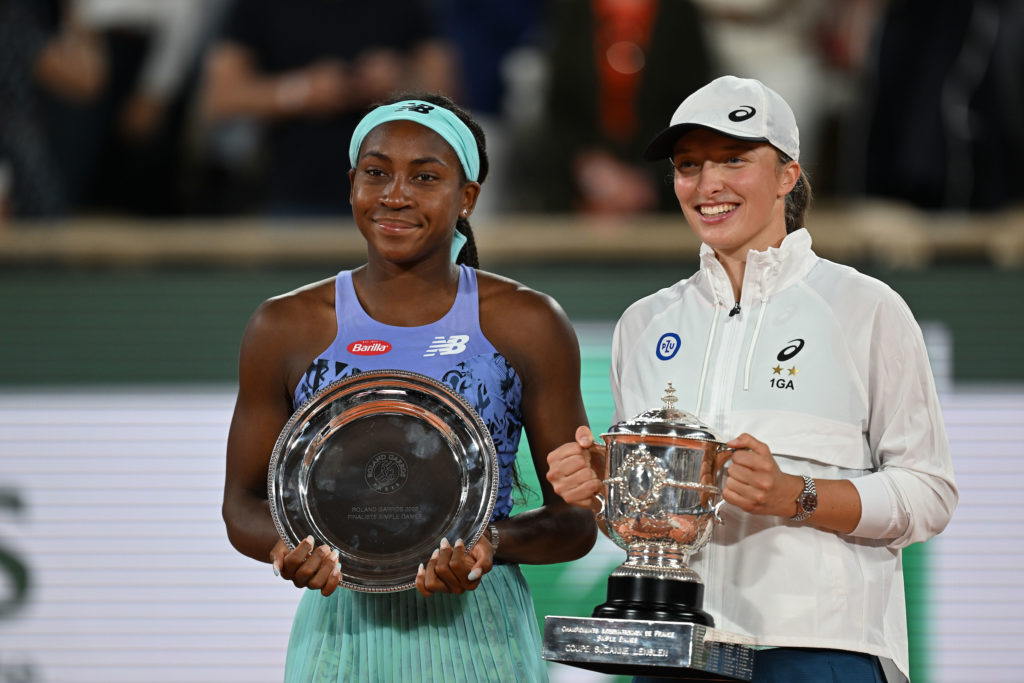 Iga Swiatek poses with Coco Gauff with the Roland Garros winner's and runner's up trophies