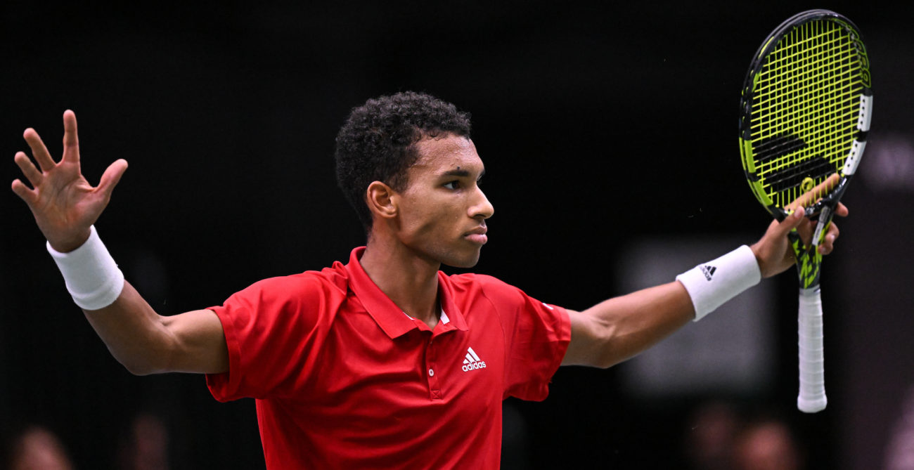 Felix Auger-Aliassime raises his arms in celebration.