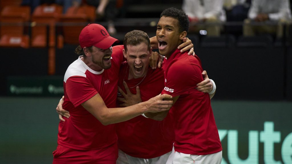 Felix Auger Aliassime, Vasek Pospisil, and Frank Dancevic celebrate victory over Spain in a group hug