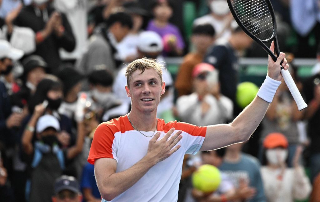 Denis Shapovalov raises his racquet and acknowledges the crowd.