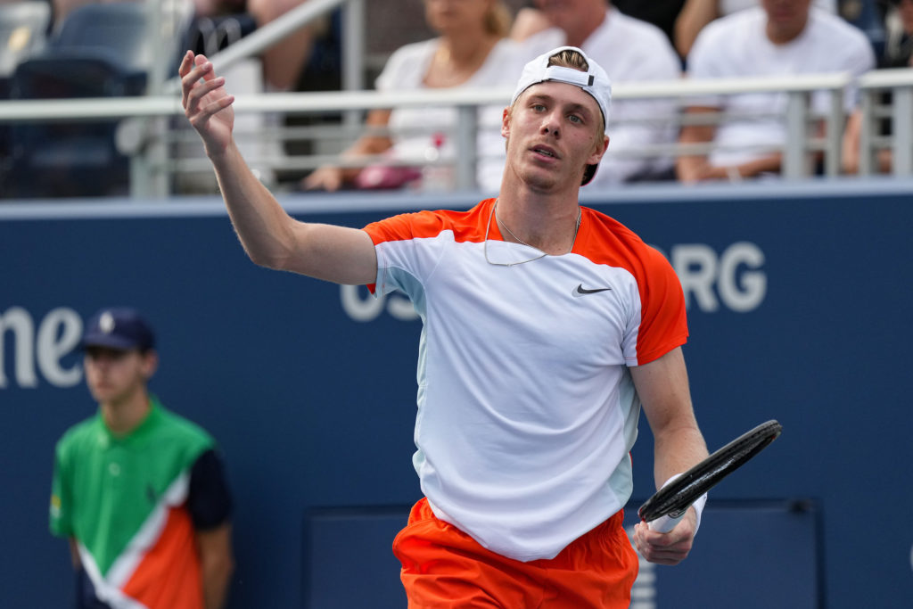 Denis Shapovalov raises a hand in the air to express frustration.