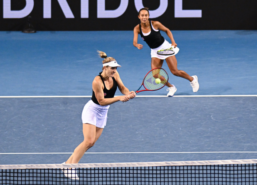 Gabriela Dabrowski hits a volley while Leylah Fernandez looks on from the baseline