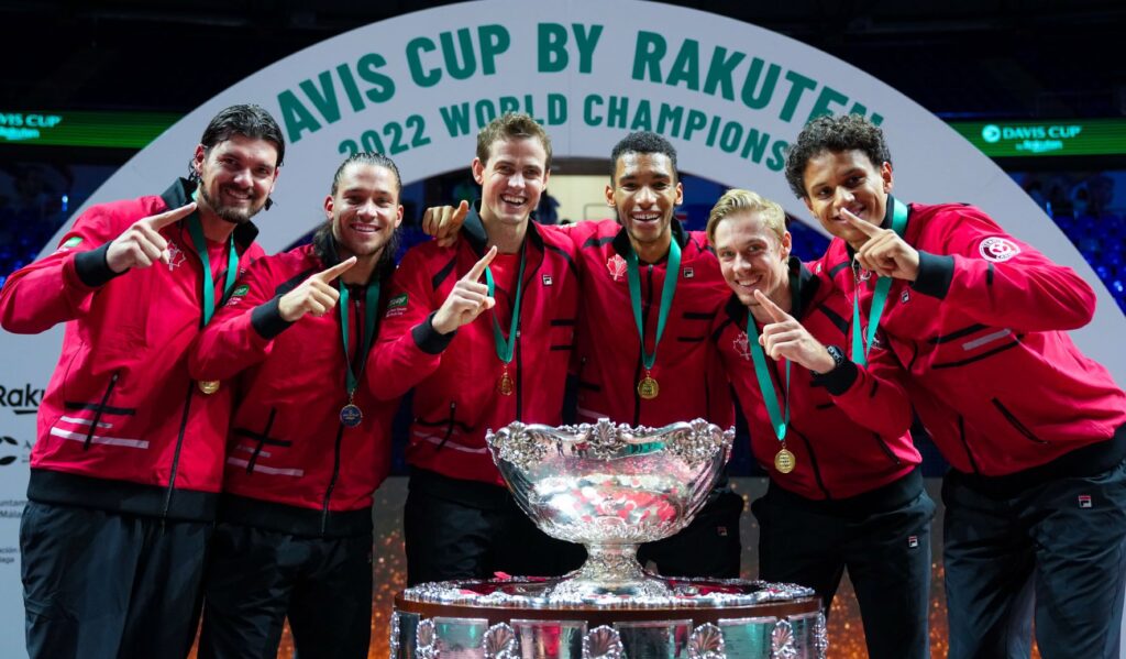 Frank Dancevic, Alexis Galarneau, Vasek Pospisil, Felix Auger-Aliassime, Denis Shapovalov, and Gabriel Diallo stand behind the Davis Cup trophy.
