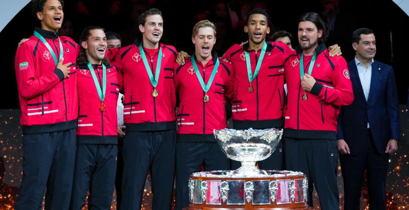 From left to right, Gabriel Diallo, Alexis Galarneau, Vasek Pospisil, Denis Shapovalov, Felix Auger-Aliassime and Frank Dancevic stand behind the Davis Cup trophy and sing O Canada