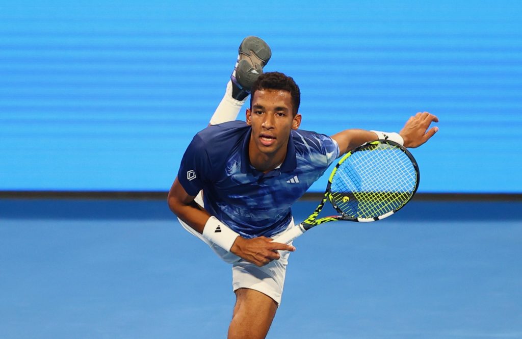 Felix Auger-Aliassime follows through on a serve.