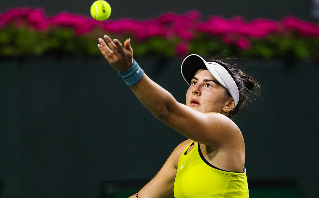Bianca Andreescu tosses up a ball to serve.