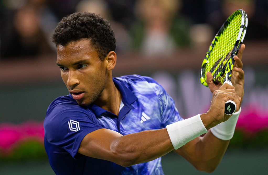 Felix Auger-Aliassime winds up to hit a slice backhand.