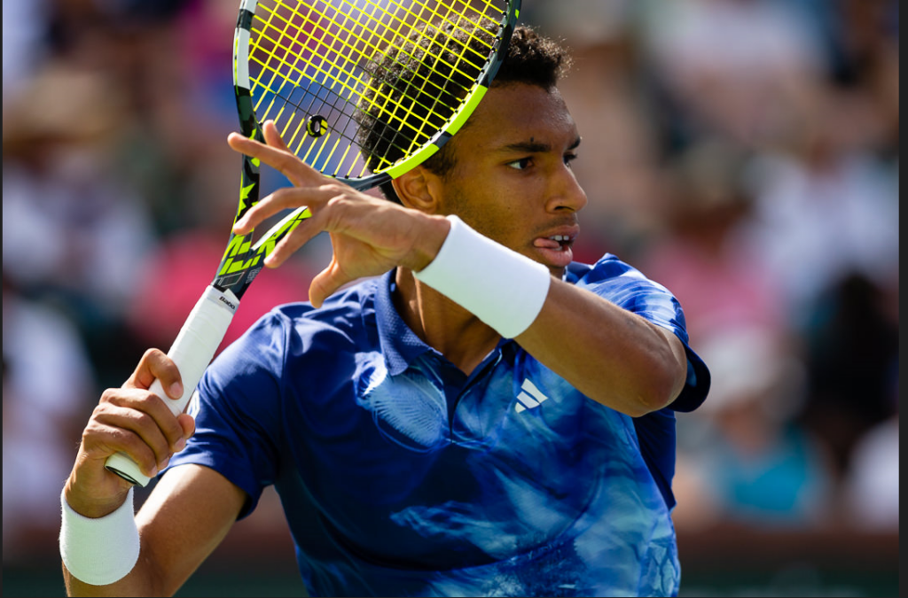 Felix Auger-Aliassime winds up to hit a forehand.