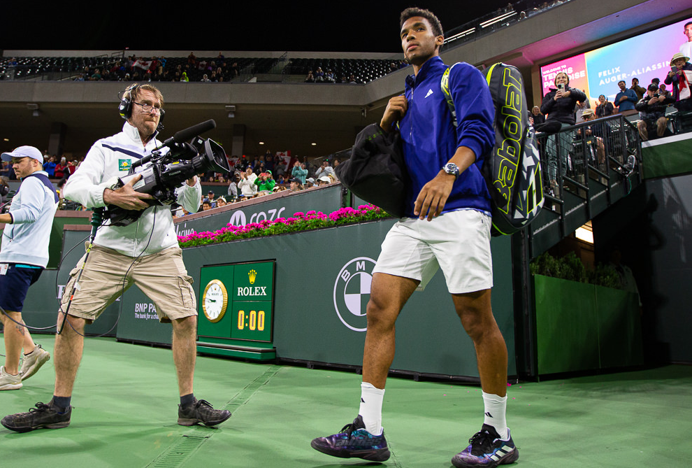 Felix Auger-Aliassime walks onto the court.