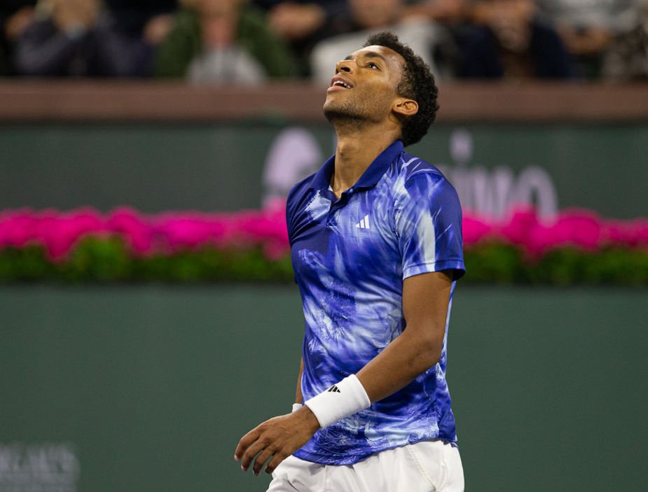 Felix Auger-Aliassime throws his head back and smiles in relief.