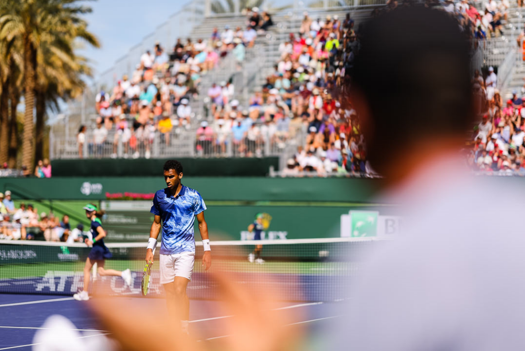 Felix Auger-Aliassime is visible from behind a fan.