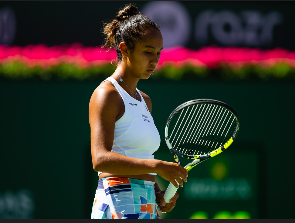 Leylah Fernandez looks down and fidgets with her racket.