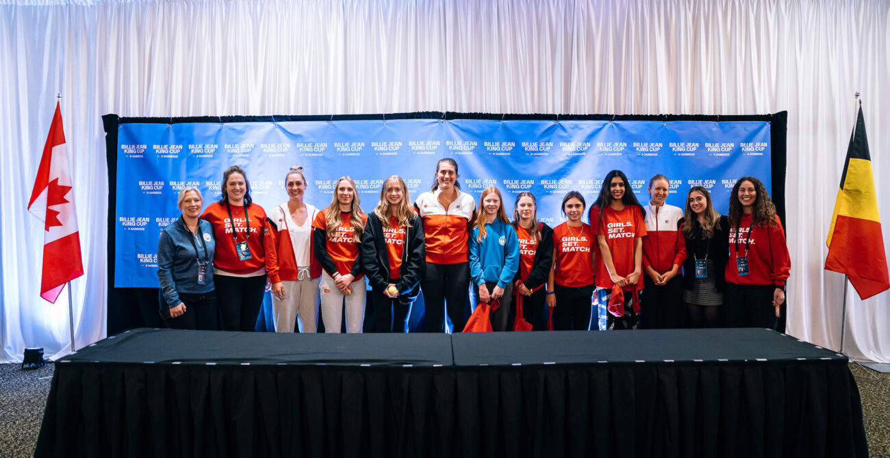 Members to Team Canada pose for a photo in the press room with local girls.