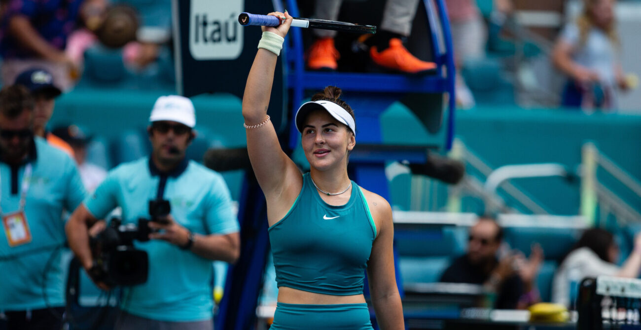 Bianca Andreescu raises her racket over her head to acknowledge the crowd.