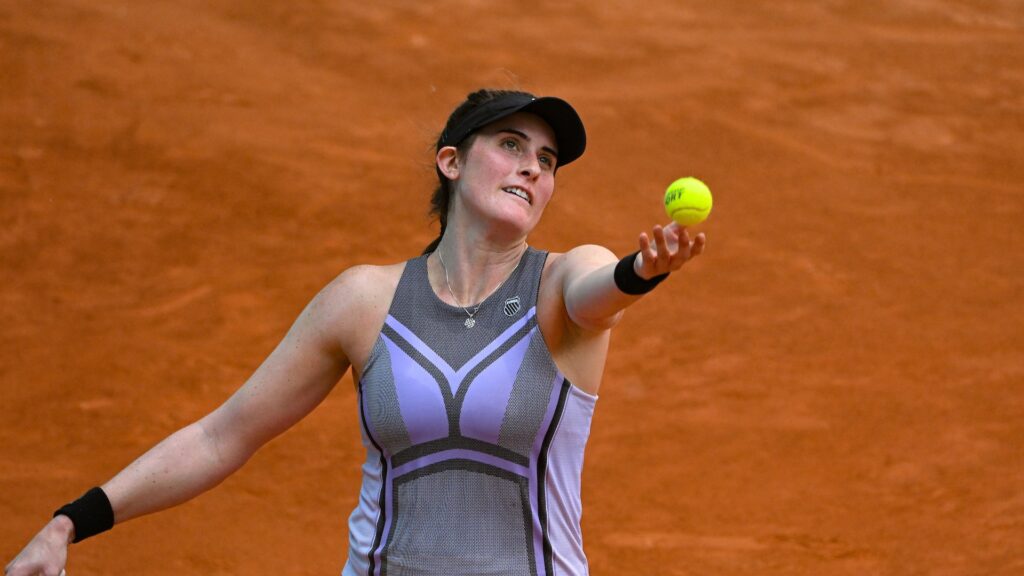 Rebecca Marino tosses a ball up to serve.