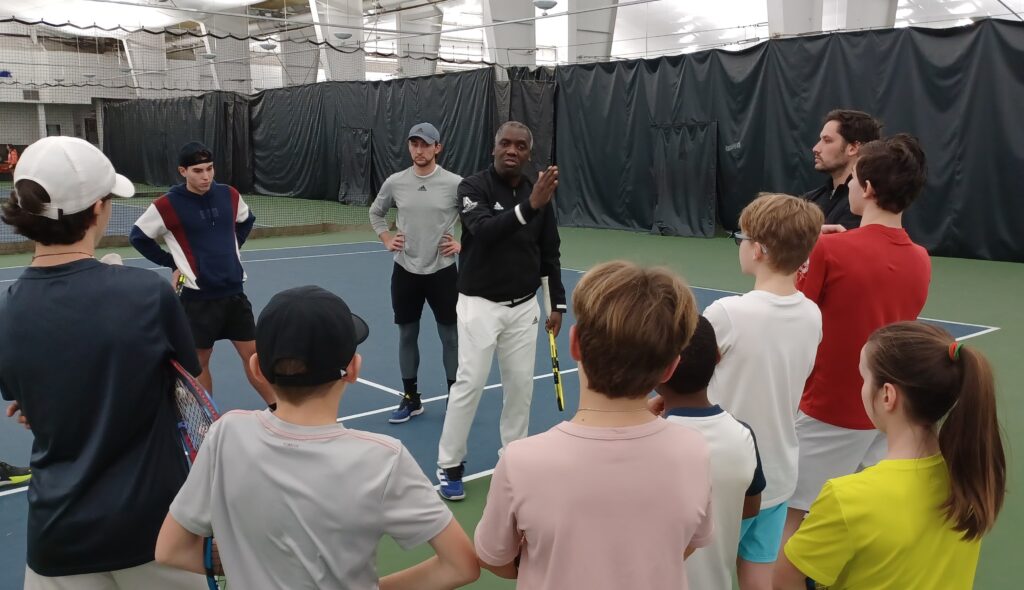 Sam Aliassime speaks to a group of students at his academy.