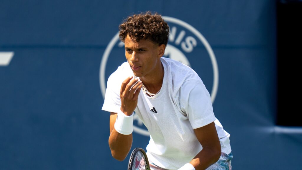 Gabriel Diallo blows on his hand while waiting to return serve.