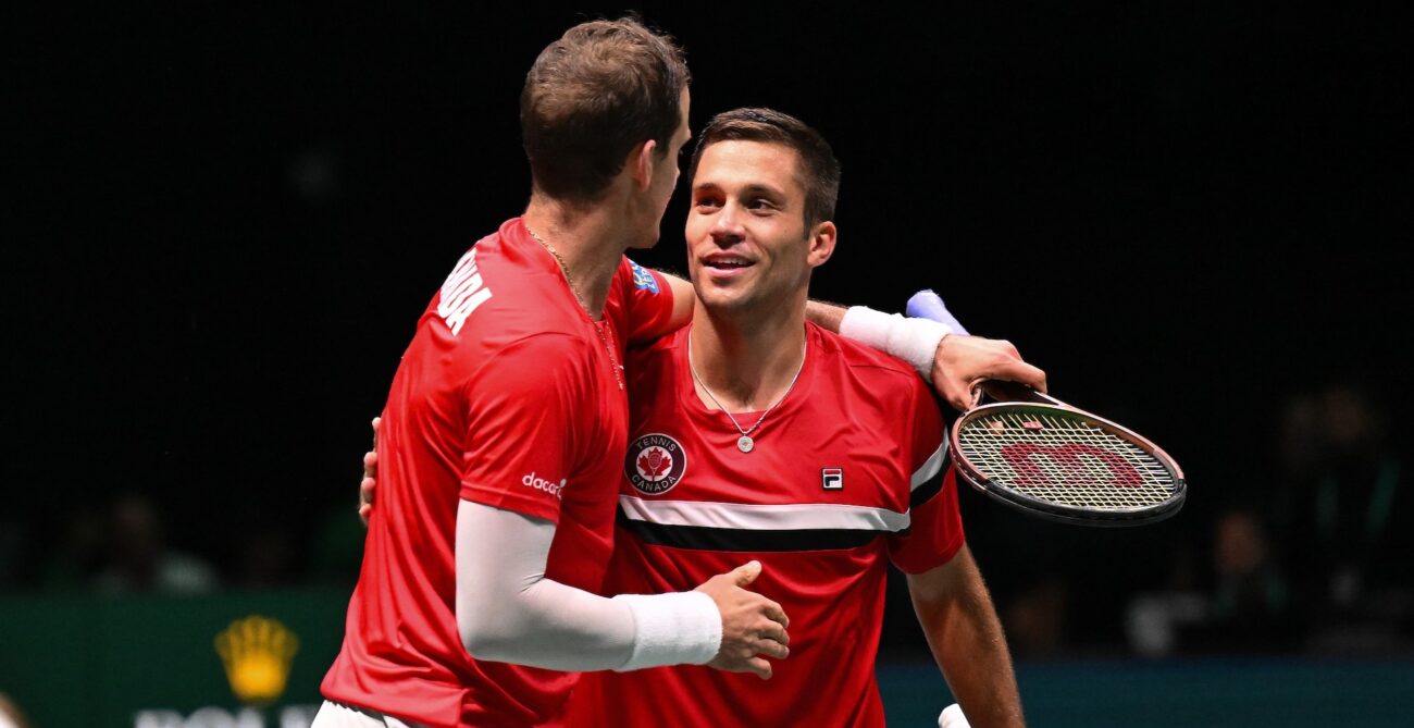 Vasek Pospisil (back to camera) puts his arm around Alexis Galarneau.